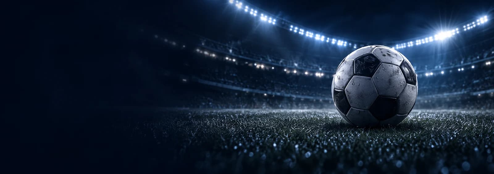 Bola de futebol num estádio iluminado